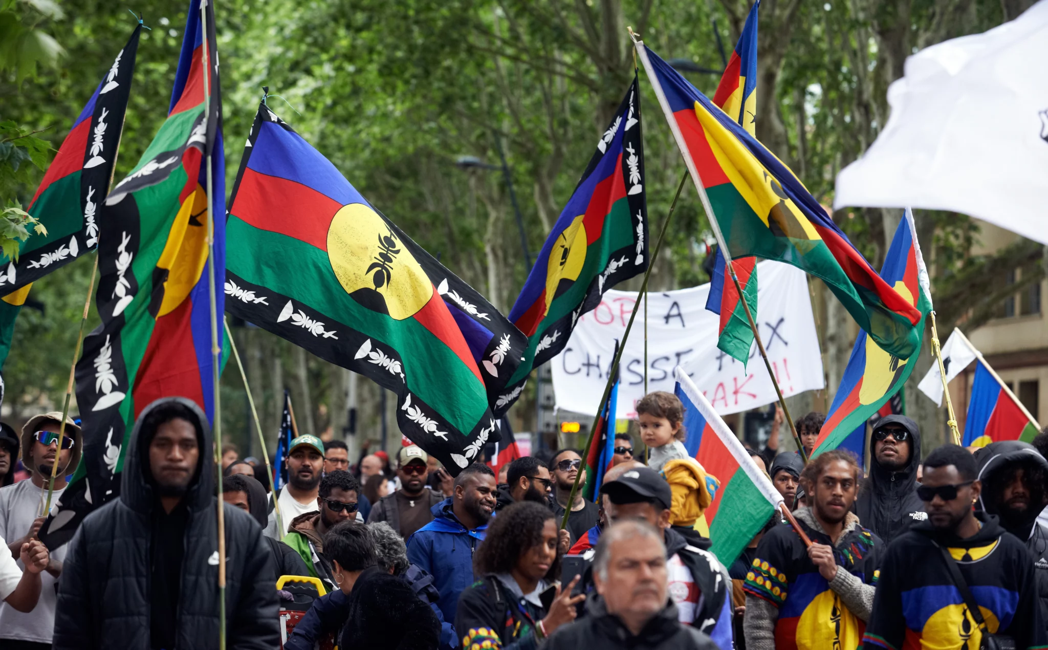 Protesters in New Caledonia waving Kanak independence flags during a demonstration amid the 2024 political unrest.