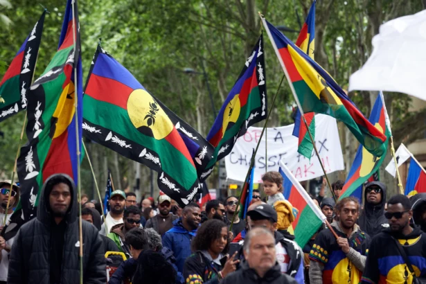 Protesters in New Caledonia waving Kanak independence flags during a demonstration amid the 2024 political unrest.